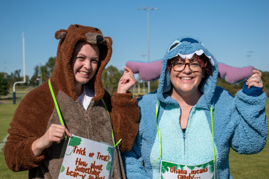 Two women dressed in costumes, smiling and posing for the camera.