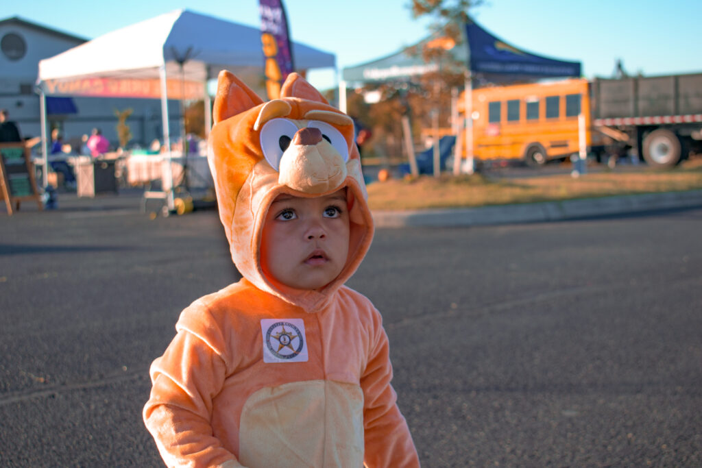 A child in a Halloween costume looking up.