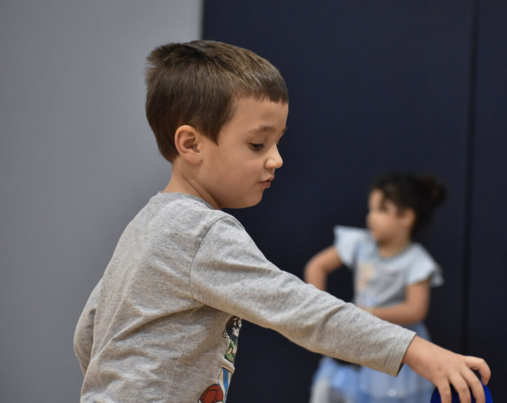 A child placing a ball on a tee.