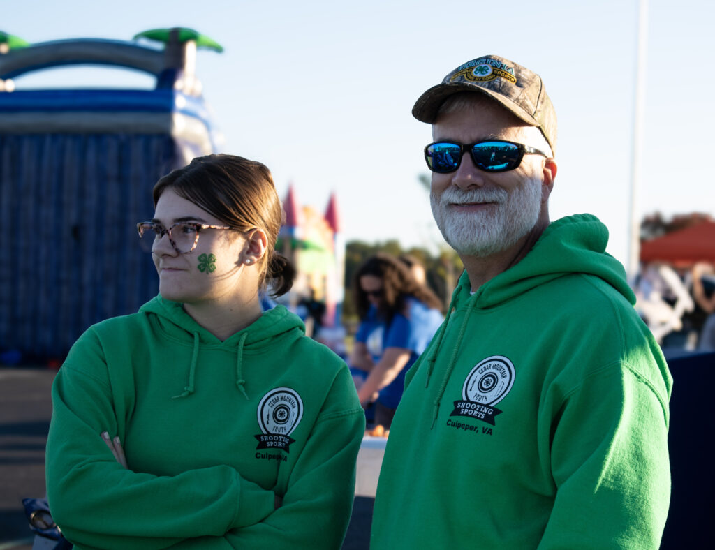 A man and woman both smiling, the man is looking towards the camera while the woman is looking to the left.