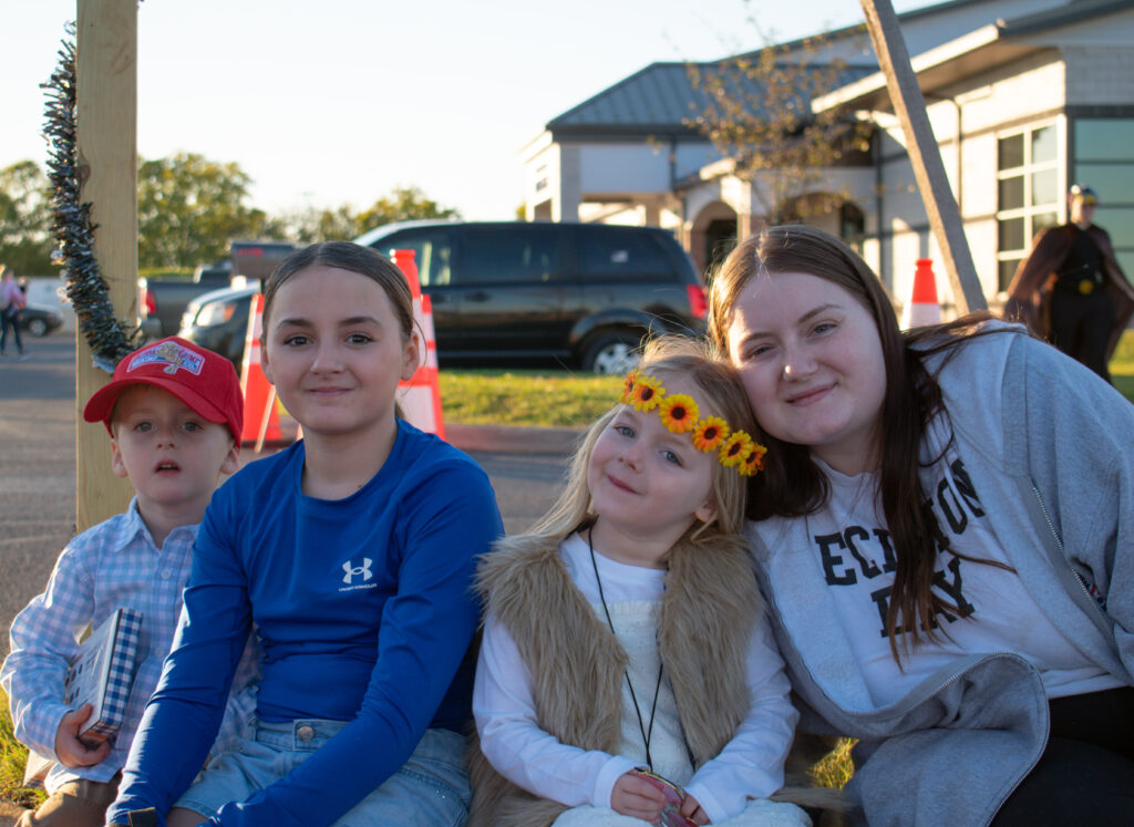 Four children sitting together, smiling at the camera.