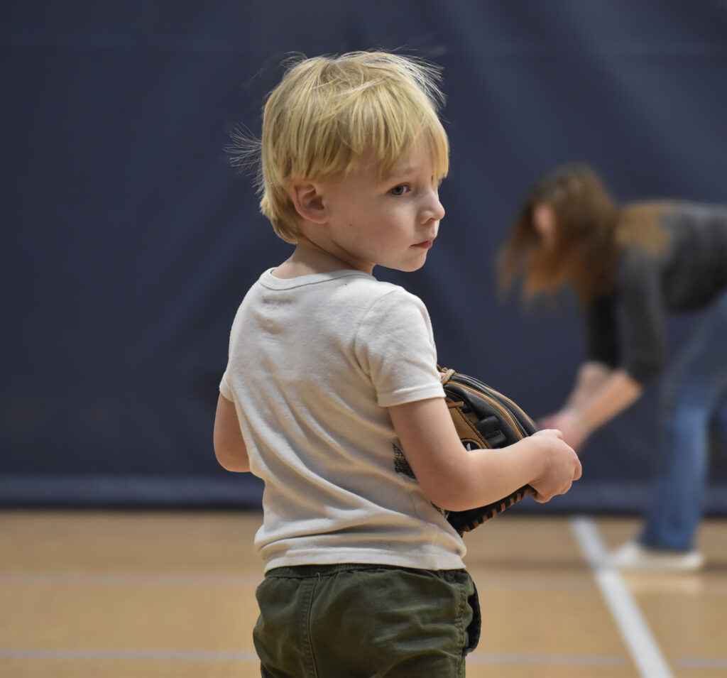 Child standing with his back towards the camera while looking over his shoulder.