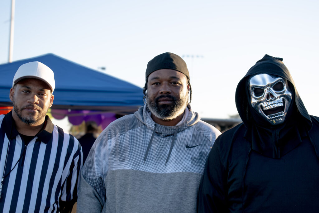 Three men in costumes looking at the camera.