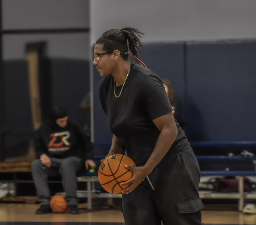 Man dribbling basketball while running and looking to the left.