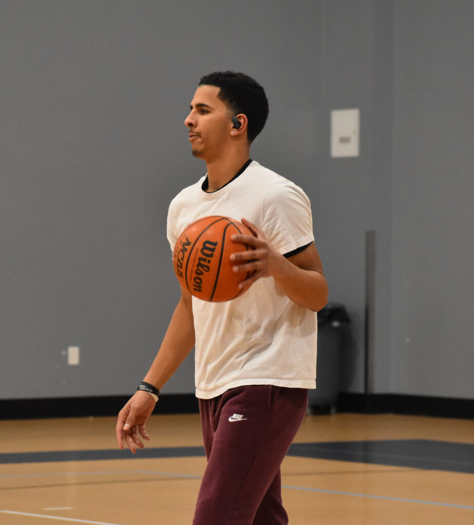 Man walking left while dribbling basketball.