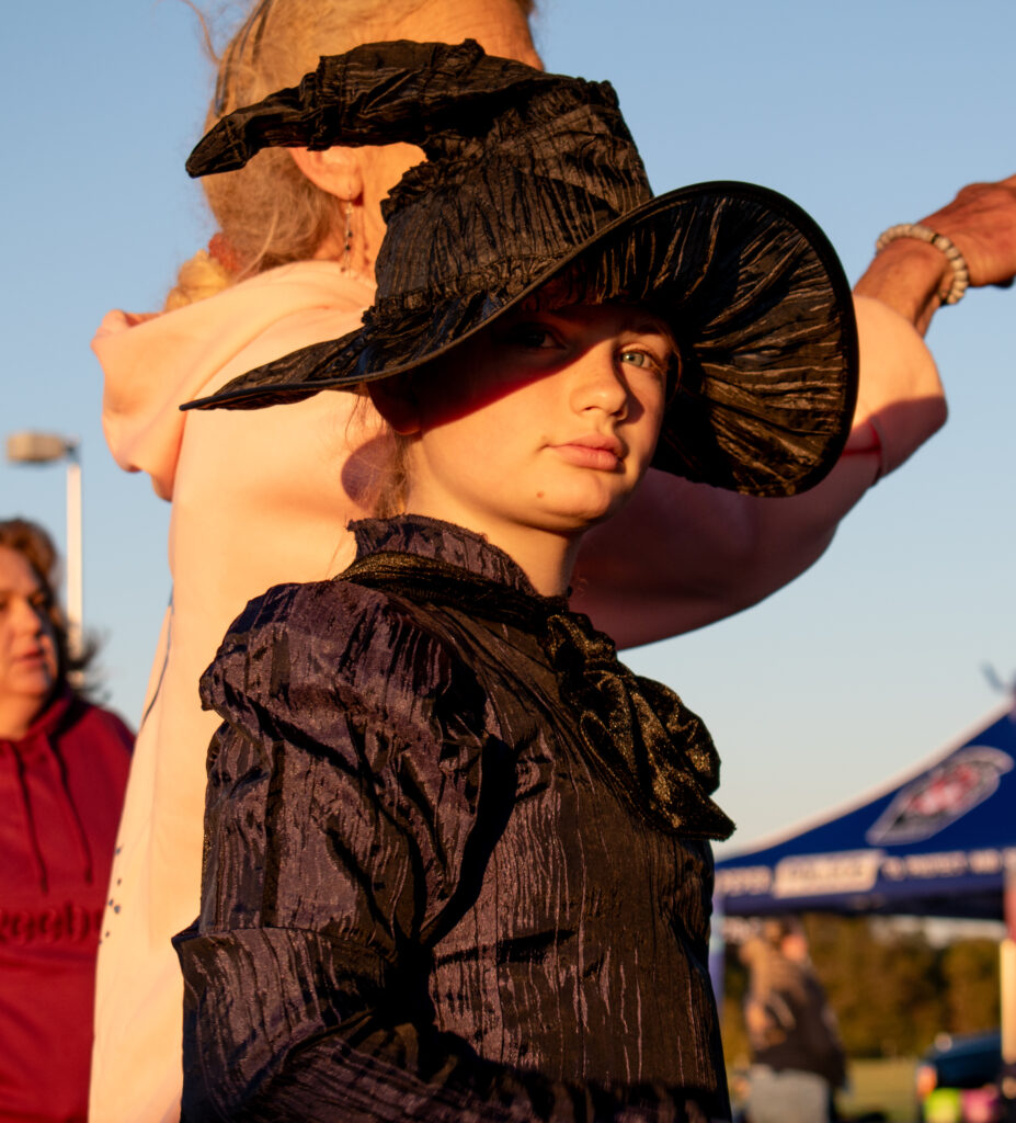 A child in a witch costume looking to the right.