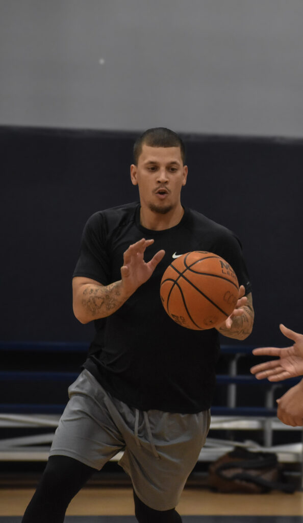 Man running towards the camera while a basketball is being passed to him.