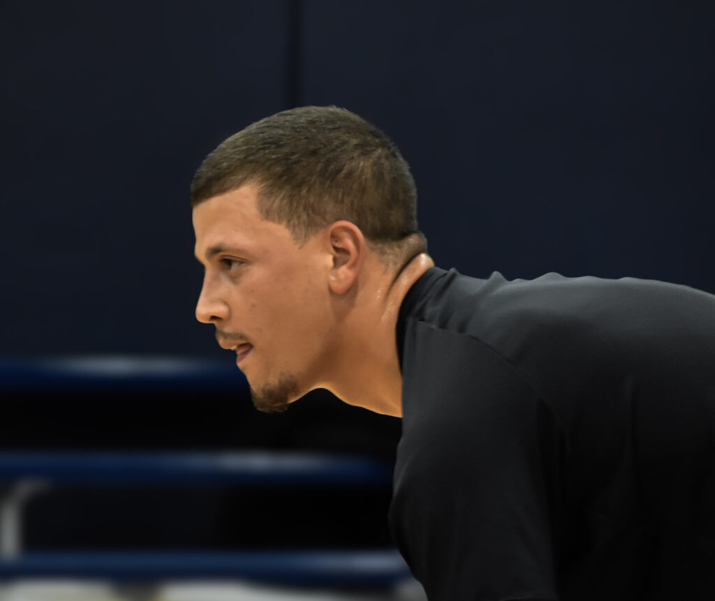 Man leaned down looking to the left.