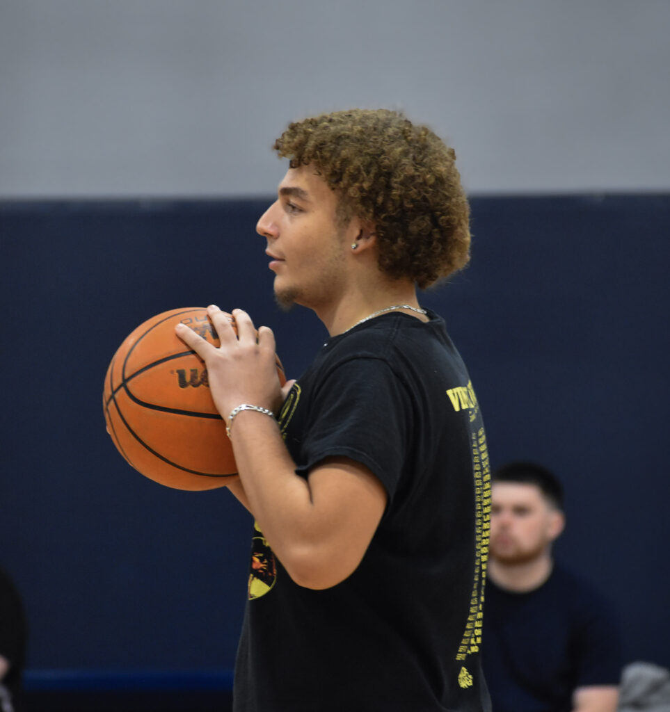 Man looking to the left while holding a basketball.